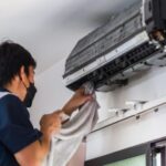 Industrial AC service technician maintaining a cooling system in an Al Quoz warehouse Dubai