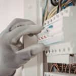 Technician inspecting air conditioner after circuit breaker trip in Dubai