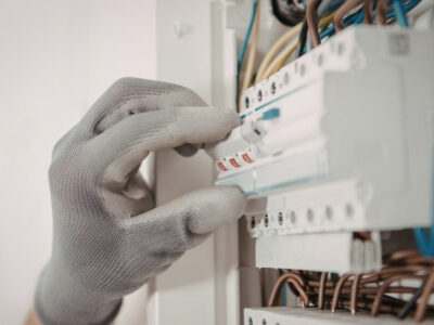 Technician inspecting air conditioner after circuit breaker trip in Dubai