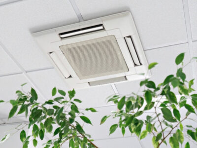 Technician inspecting centralized AC damper system in a large Dubai villa to fix uneven cooling