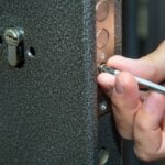 Technician repairing door lock in Dubai home using tools for security fix