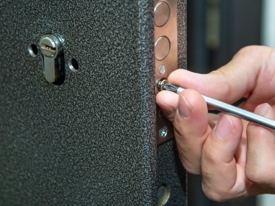 Technician repairing door lock in Dubai home using tools for security fix