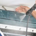Technician cleaning air conditioner indoor unit filter in Dubai home for better cooling performance