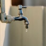 Homeowner checking a dry water tap after sudden water supply interruption in Dubai