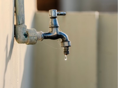 Homeowner checking a dry water tap after sudden water supply interruption in Dubai