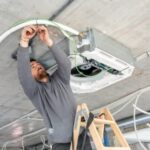 Technician inspecting VAV box in a Dubai office commercial AC system
