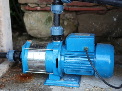 Technician checking water pump and plumbing system in a Dubai home